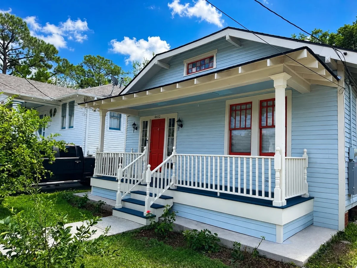 After: an angled view of the raised front porch and updated columns, steps, and railings.