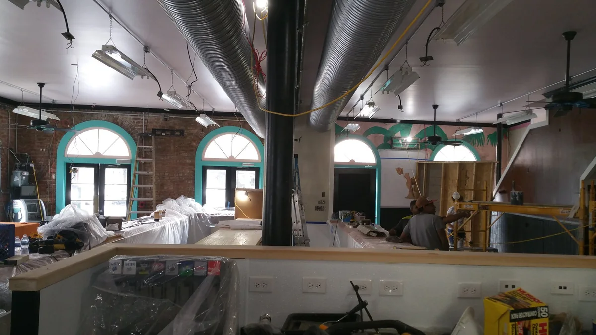The open dining room and central bar during interior renovation.