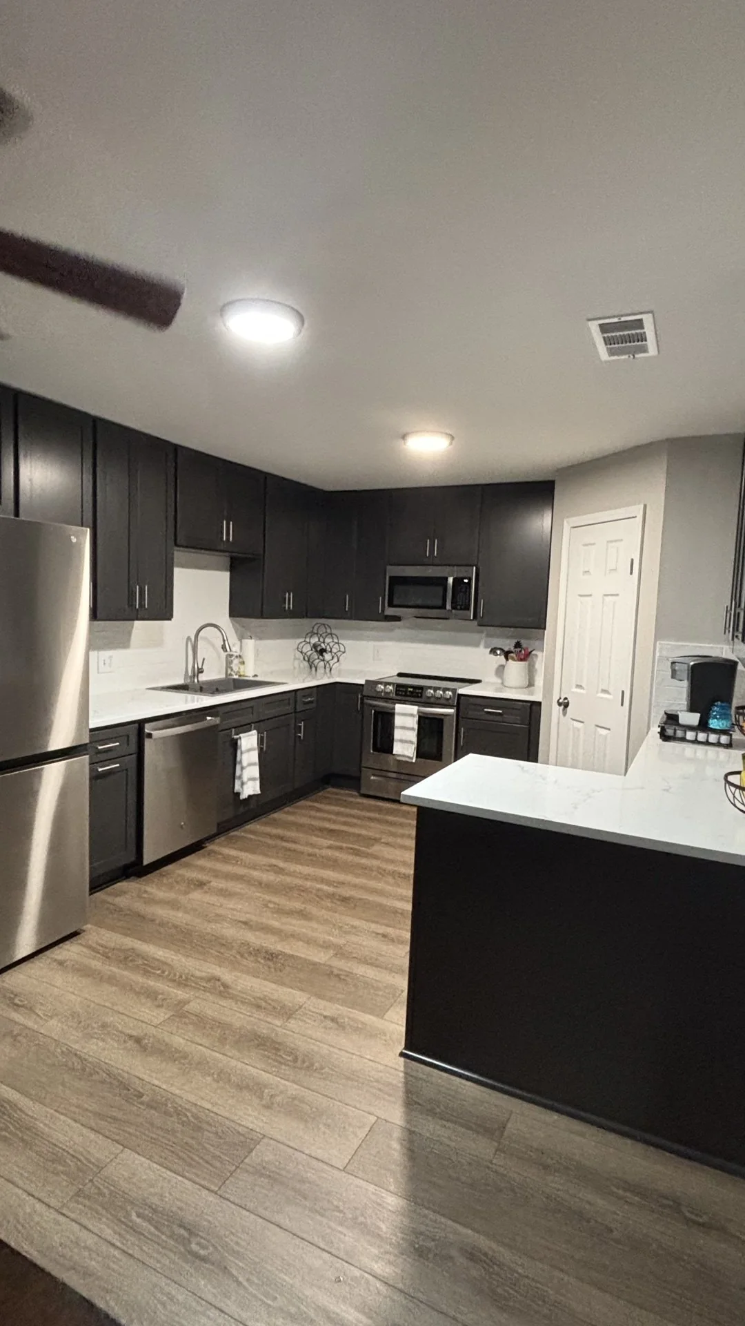 Kitchen with dark cabinetry and white countertops