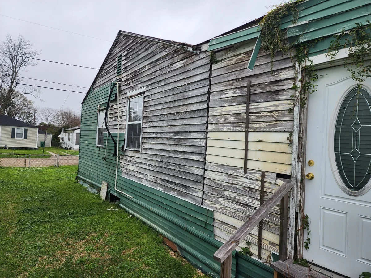 Before renovation: the existing exterior and worn siding.