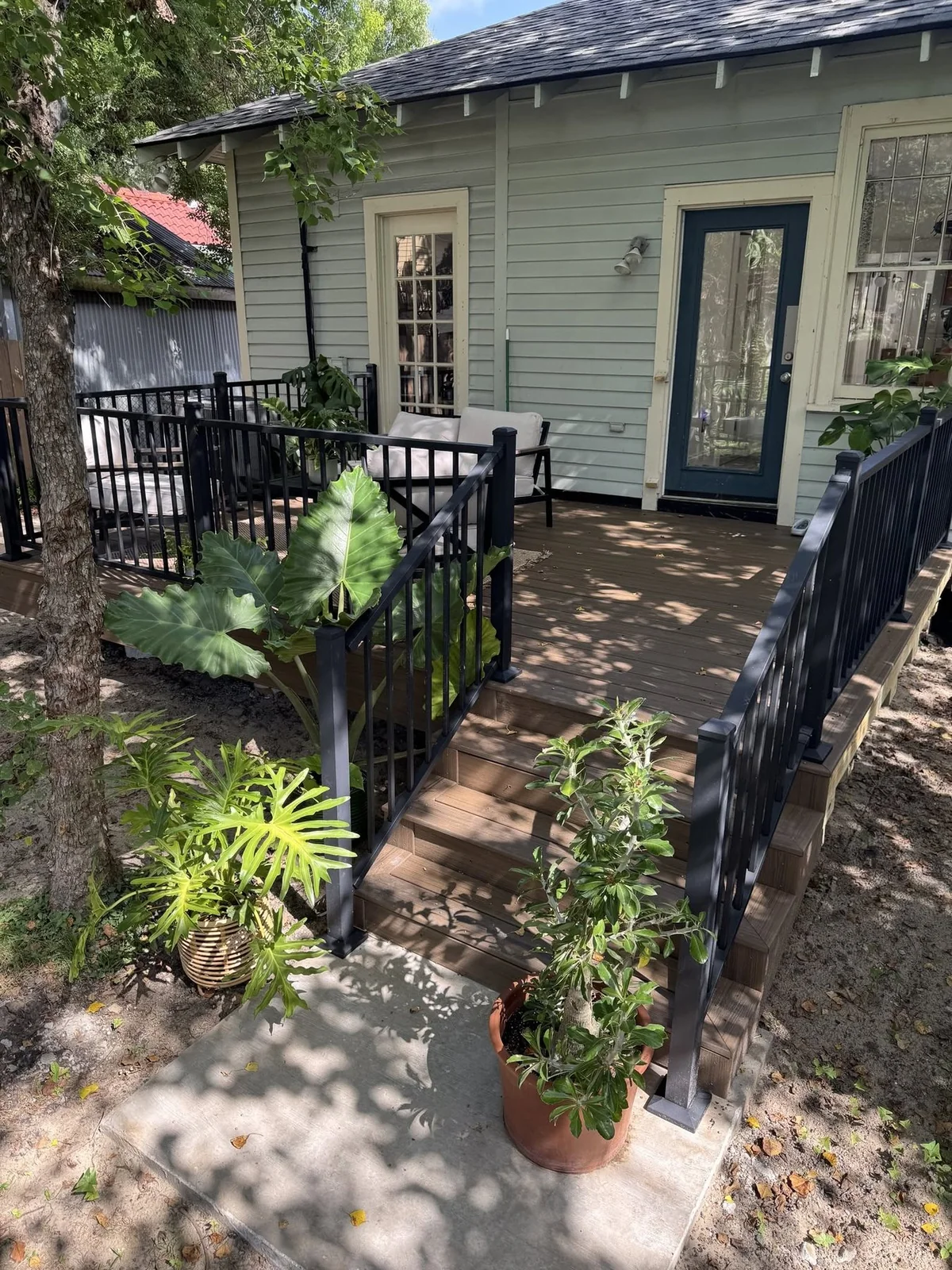 After: raised rear deck with composite decking, metal posts, and railings.