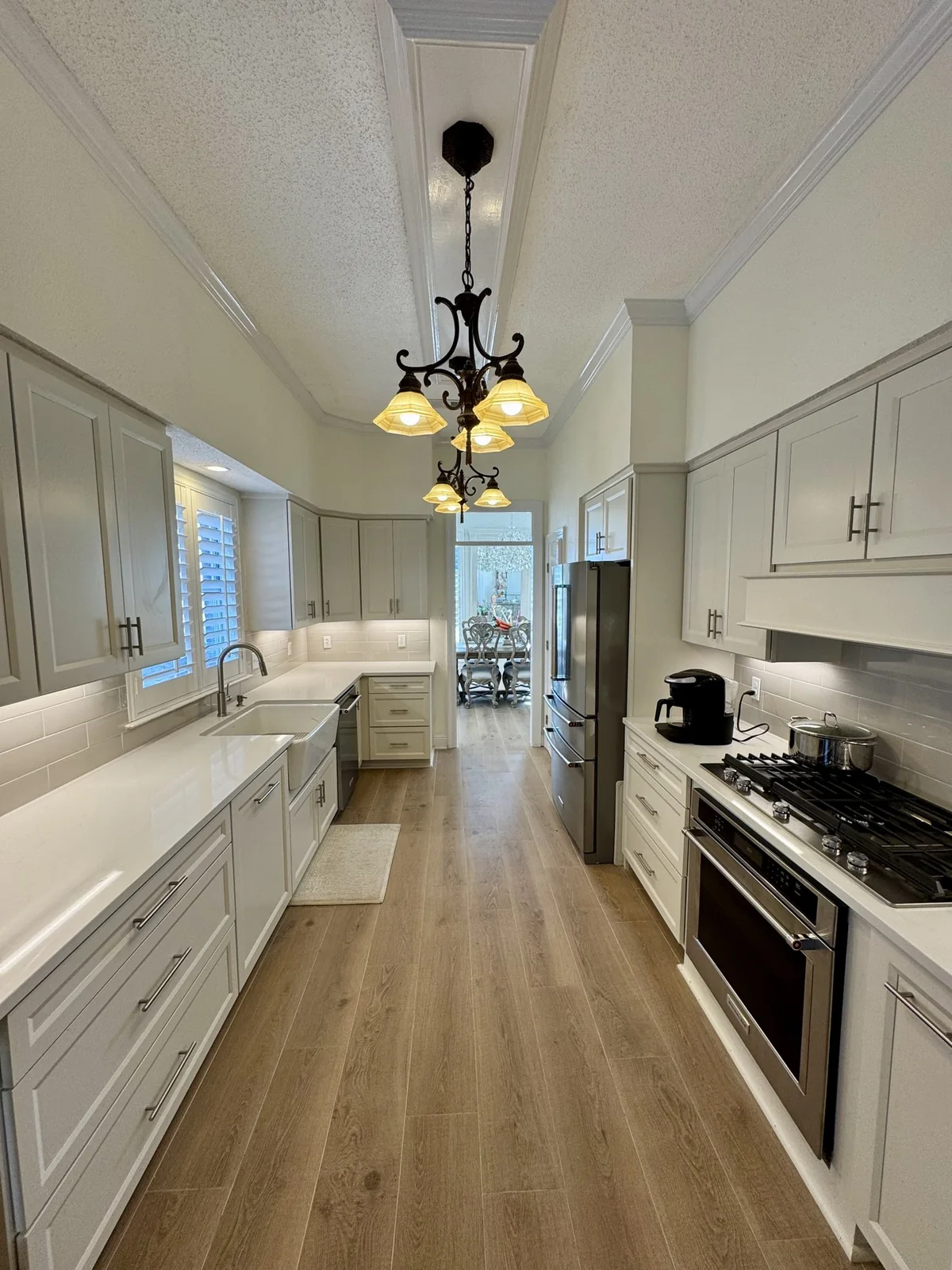 White galley kitchen with warm pendant lighting
