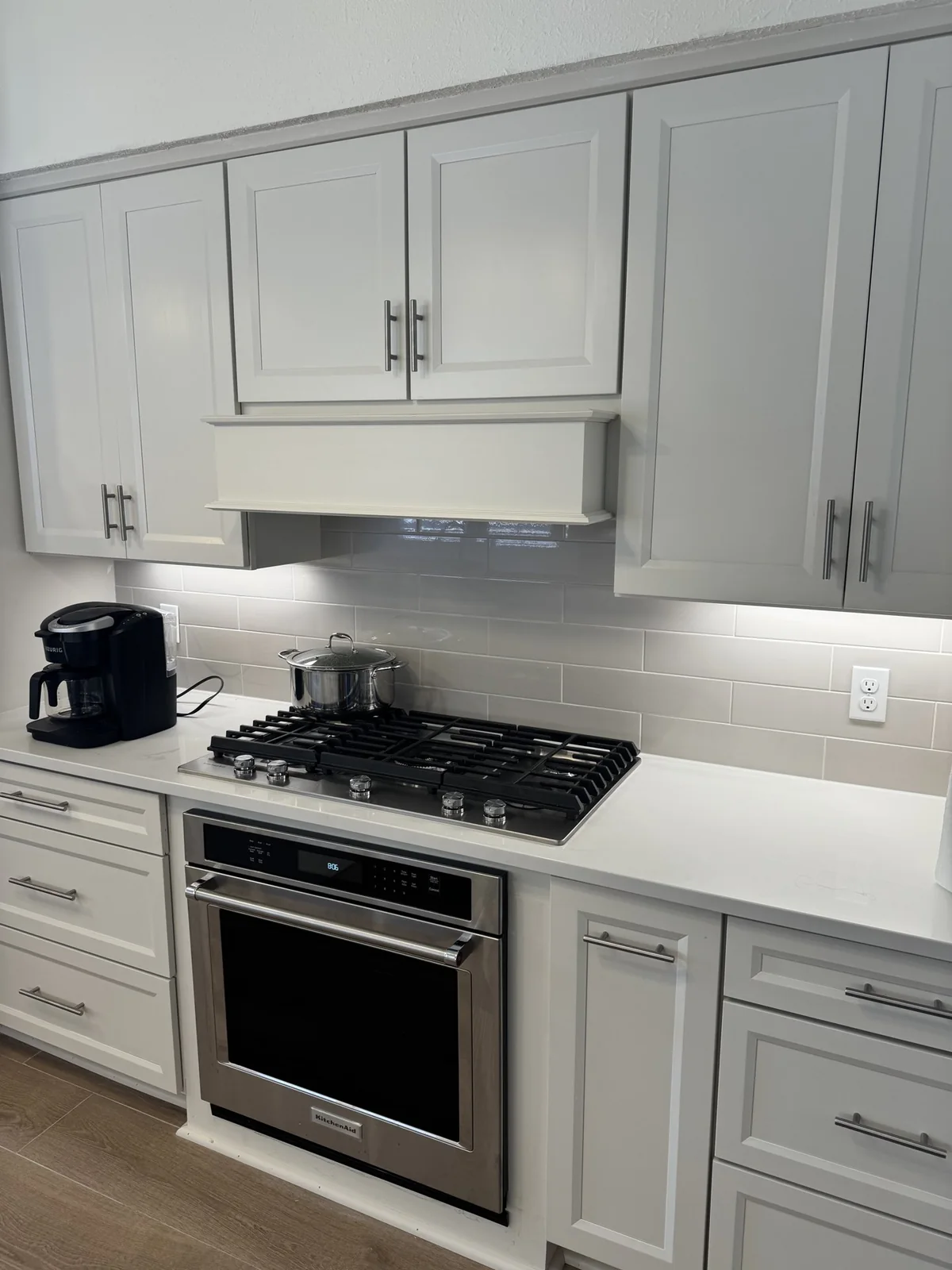 Gas cooktop, oven and white cabinetry