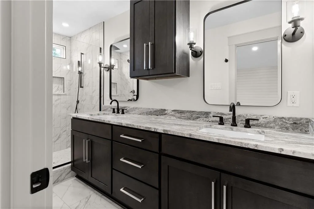 Completed bathroom with a double vanity and tiled shower.