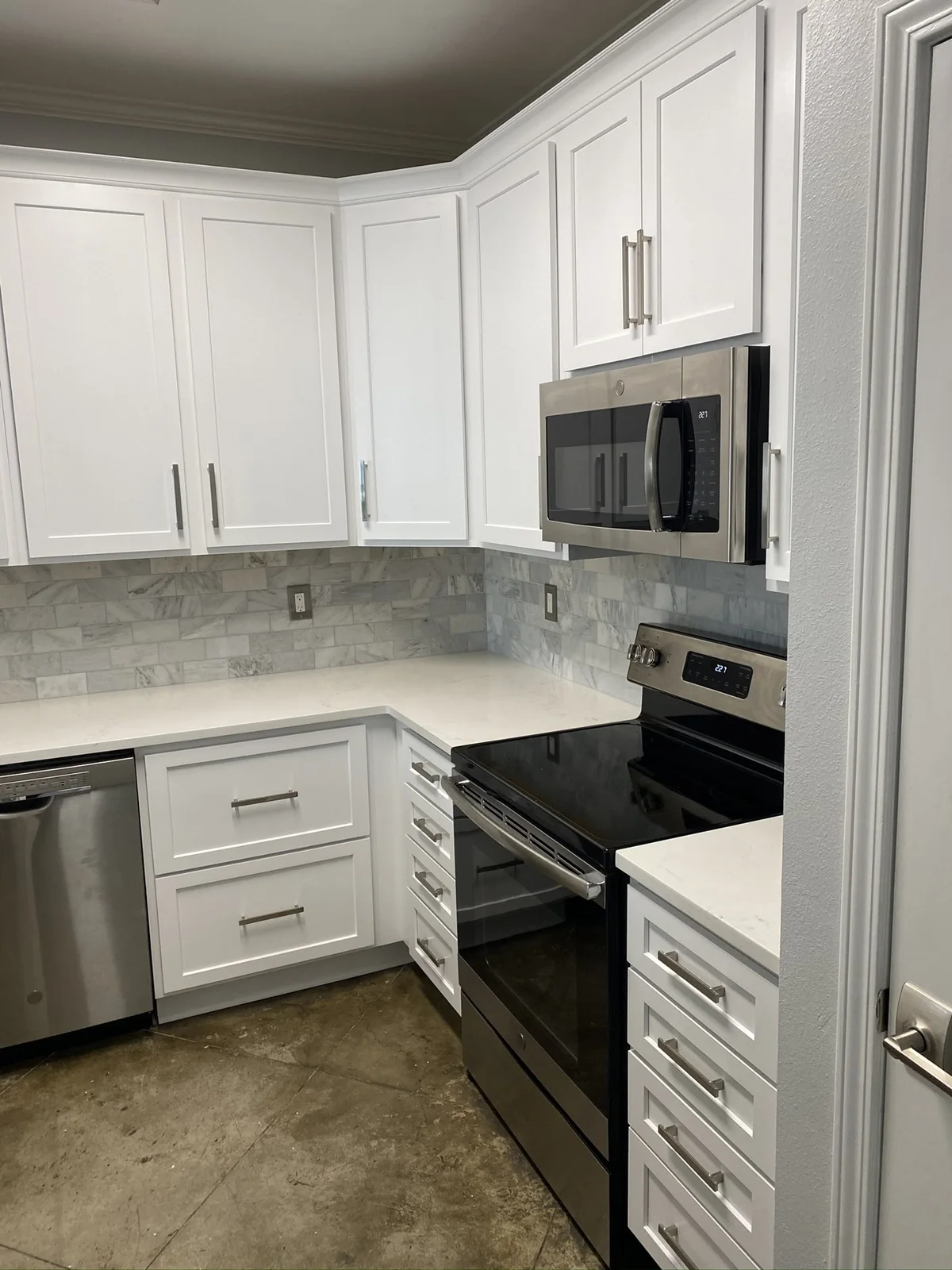Range and microwave with pale tile backsplash