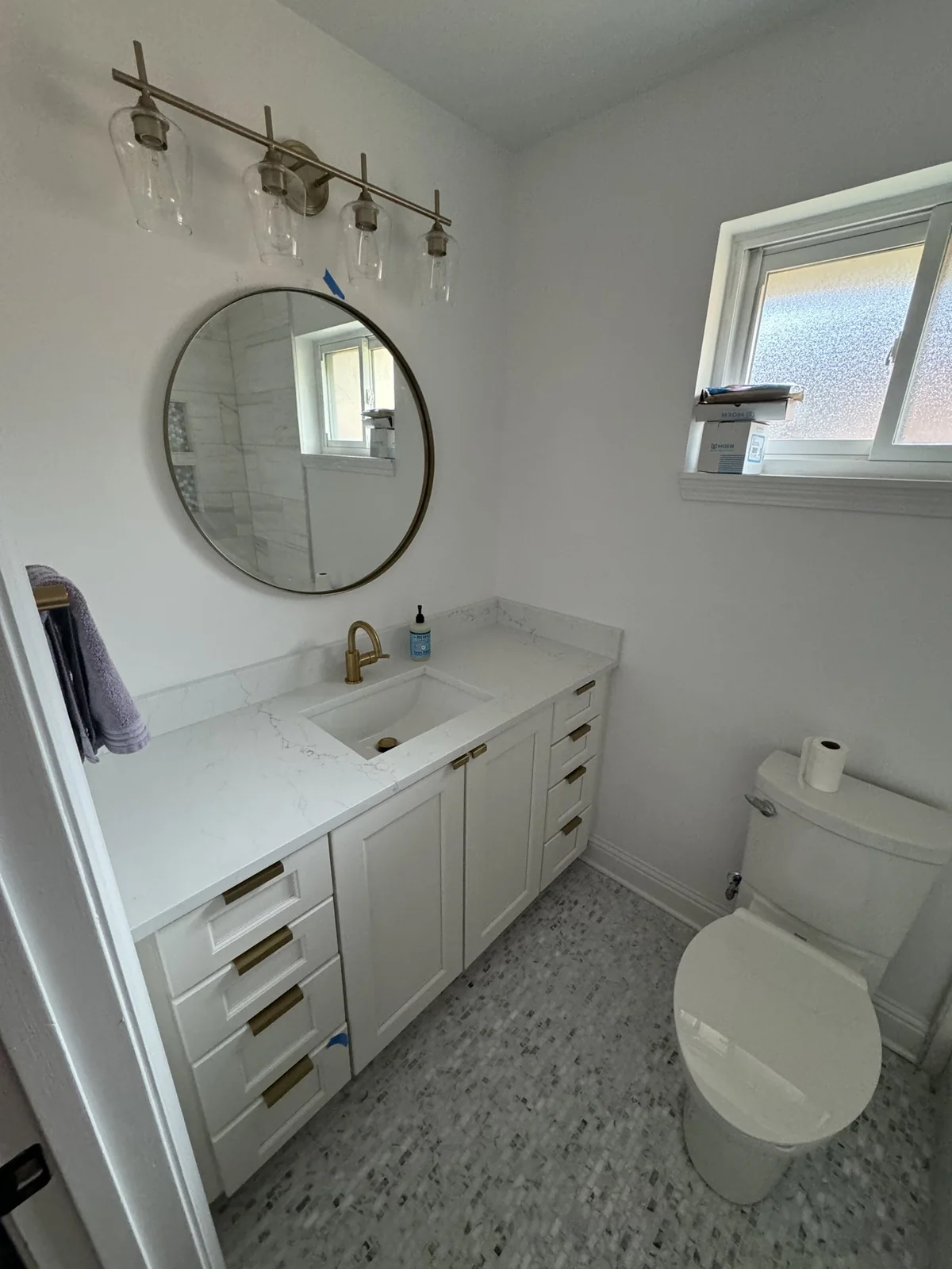 White vanity with brass fixtures — installation materials visible