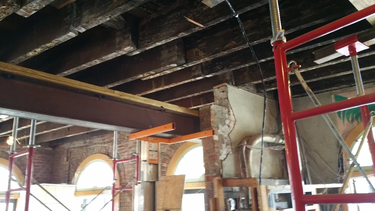 Structural work and exposed ceiling framing during the restaurant renovation.