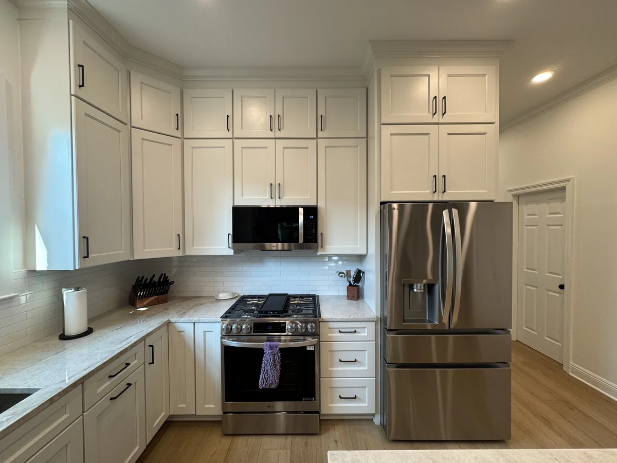 Range, refrigerator, and surrounding cabinetry