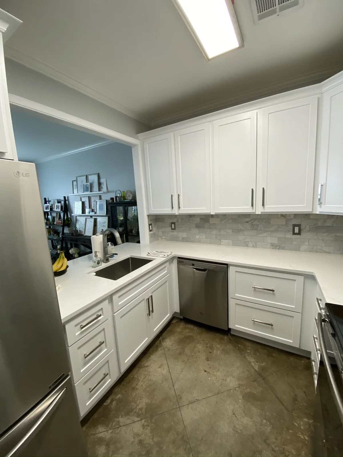 Sink and dishwasher beneath white cabinetry