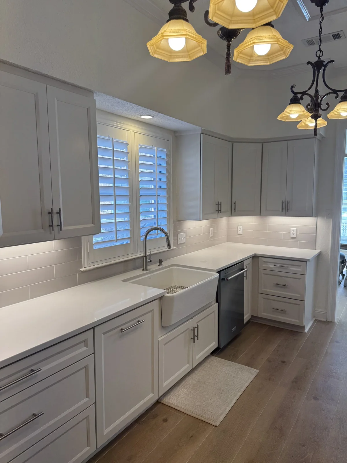 Apron-front sink beneath shuttered windows